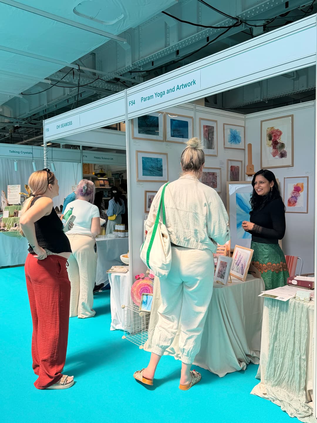 Nikita showing artwork to a visitor at MindBodySpirit Festival